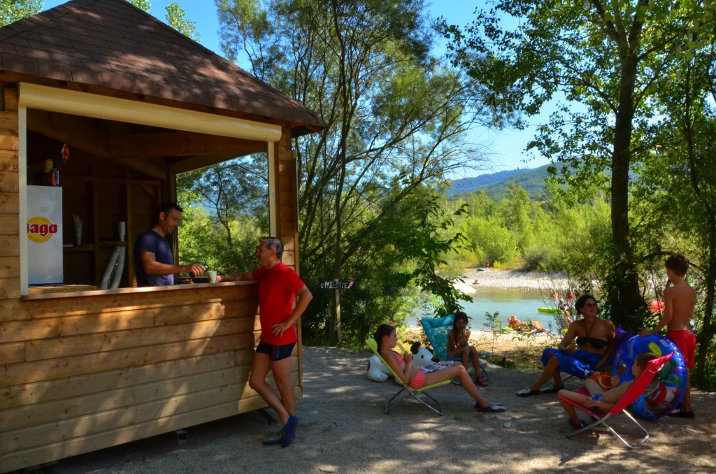 La Paillotte, devant la rivière, un jus de fruit est servi à un client