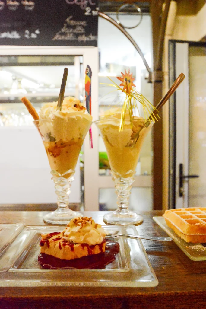 Deux coupes de glaces avec un dessert en premier plan